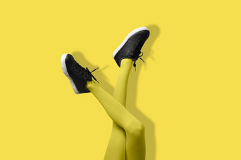 新黑色的女运动鞋长纤细的女人腿<strong>黄色</strong>的连裤袜孤立的<strong>黄色</strong>的背景单色流行艺术概念新黑色的女运动鞋长纤细的女人腿<strong>黄色</strong>的连裤袜孤立的<strong>黄色</strong>的背景