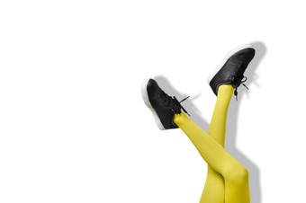新黑色的女运动鞋长纤细的女人腿黄色的连裤袜孤立的白色背景新黑色的女运动鞋长纤细的女人腿黄色的连裤袜孤立的白色背景