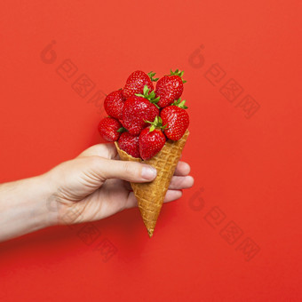 冰奶油锥填满与成熟的草莓孤立的红色的背景手持有华夫格锥与成熟的草莓夏天横幅冰奶油锥填满与成熟的草莓孤立的红色的背景手持有华夫格锥与成熟的草莓夏天横幅