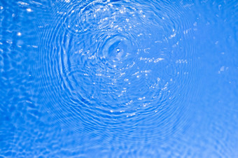 表面蓝色的透明的游泳池水纹理与圈的水时尚的摘要自然背景水波太阳光反射表面蓝色的透明的游泳池水纹理与圈的水时尚的摘要自然背景水波太阳光反射