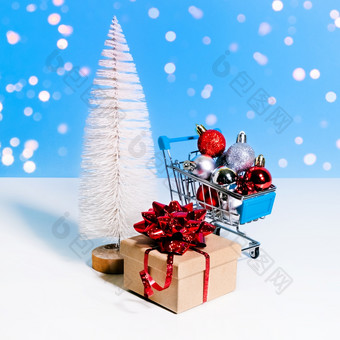 美丽的圣诞节新一年出售横幅玩具圣诞节树<strong>礼物盒子</strong>与红色的弓和购物电车完整的圣诞节装饰物蓝色的背景与模糊灯美丽的圣诞节新一年出售横幅玩具圣诞节树<strong>礼物盒子</strong>与红色的弓和购物电车完整的圣诞节装饰物蓝色的背景与模