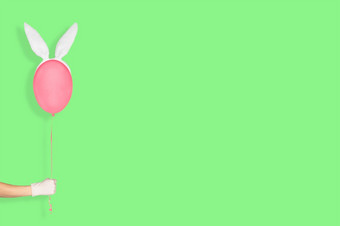 有创意的复活节最小的概念手白色手套持有粉红色的<strong>气球</strong>兔子耳朵孤立的柔和的绿色背景复活节<strong>横幅</strong>与复制空间有创意的复活节最小的概念手白色手套持有粉红色的<strong>气球</strong>兔子耳朵孤立的柔和的绿色背景复活节<strong>横幅</strong>与复制空间