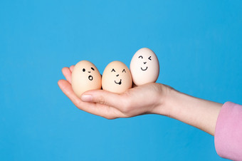 手持有<strong>三个</strong>复活节鸡蛋与有趣的脸画复活节健康的饮食吃概念手持有<strong>三个</strong>复活节鸡蛋与有趣的脸画复活节健康的饮食吃概念