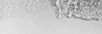 光灰色的透明的清晰的平静水表面纹理与溅波和泡沫时尚的摘要自然背景水波阳光长横幅光灰色的透明的清晰的平静水表面纹理与溅波和泡沫时尚的摘要自然背景水波阳光长横幅