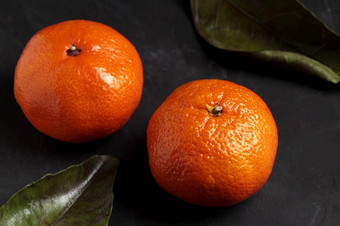 普通话黑色的背景新鲜的橘子水果与绿色叶黑暗情绪克莱门泰柑橘类植物健康的自然有机圣诞节收获健康的素食者橘子特写镜头普通话黑色的背景新鲜的橘子水果