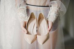 新娘白色婚礼衣服持有婚礼鞋子新娘白色婚礼衣服持有婚礼鞋子她的手