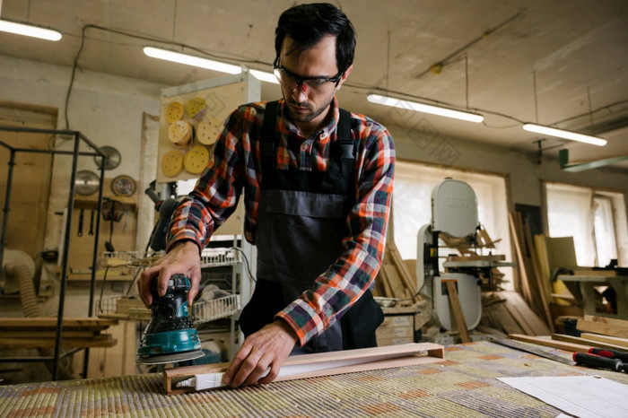 工作过程的木工车间手电砂光机为伍德尔木工车间职业木工木制品和人概念工作过程的木工车间