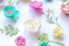 花模式色彩斑斓的手工制作的花和纸叶子隔离白色背景