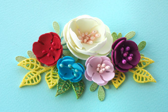 花安排色彩斑斓的手工制作的手工制作的花和叶子蓝色的背景