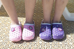 两个双孩子们rsquo脚明亮的紫色的和粉红色的海滩橡胶拖鞋