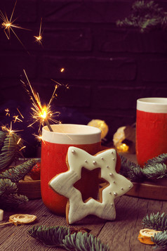 两个红色的杯子与咖啡和棉花糖燃烧炯炯有神的眼睛星形的姜饼和冷杉分支机构木背景