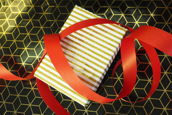 礼物盒子与条纹白色和黄金成员黑色的和黄金包装纸和红色的丝带礼物包装