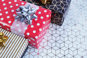 三个礼物盒子黑色的金子和红色的白色豌豆角白色纸与几何模式