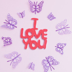 木登记爱你粉红色的背景和紫色的纸蝴蝶周围