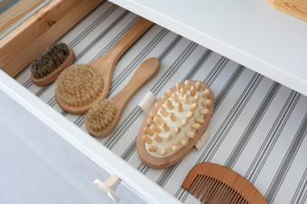 开放抽屉沙拉酱表格与刷按摩器和梳子使木和自然刷毛