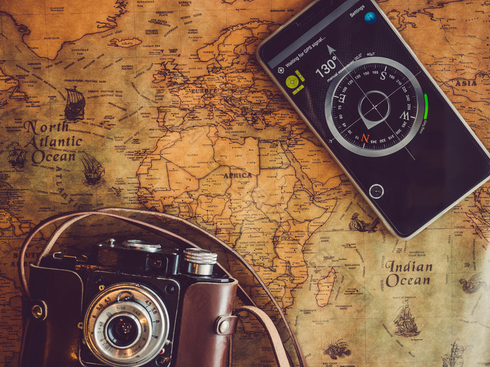 老古董地图和移动电话与图片指南针前视图特写镜头概念休闲和旅行老古董地图和移动电话前视图