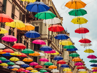 五彩<strong>缤纷</strong>的明亮的雨伞挂之间的房子的美丽的狭窄的街道的华丽的城市热那亚对的蓝色的天空阳光明媚的夏天一天概念旅行和娱乐五彩<strong>缤纷</strong>的和明亮的雨伞挂之间的房子