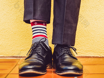 但rsquo腿时尚的鞋子色彩斑斓的袜子与模式的形式锚的背景黄色的墙概念风格时尚和美但rsquo腿时尚的鞋子和色彩斑斓的袜子
