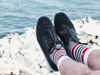 但rsquo腿体育鞋子和白色袜子与明亮的海模式的形状锚的背景岩石海岸夏天阳光明媚的一天概念时尚体育运动和娱乐但rsquo腿体育鞋子和白色袜子