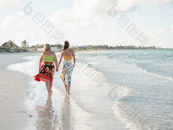 年轻的女人走沿着的海岸的大西洋海洋特写镜头假期和旅行概念年轻的女人走沿着的海岸的大西洋海洋