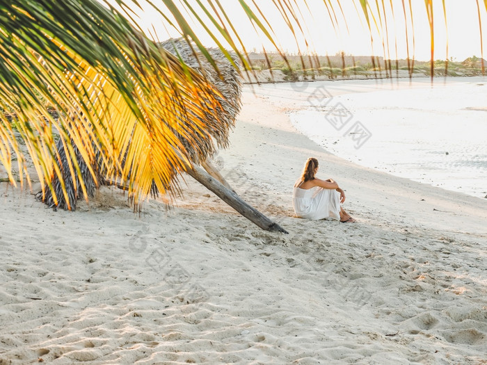 可爱的女人的海滩对的背景的海看成的距离在户外特写镜头概念休闲和旅行可爱的女人的海滩对的背景的海