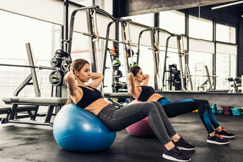 两个可爱的女孩做重运动锻炼的健身房做练习为腹部肌肉
