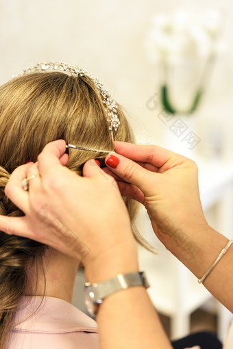 专业服务的美容沙龙年轻的女人与美丽的金发女郎头发有使发型为婚礼聚会，派对