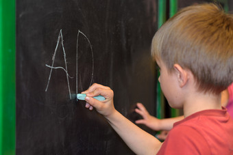 小男孩学习写黑板上的<strong>幼儿园</strong>的<strong>教室</strong>
