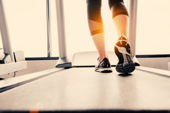 较低的身体腿部分健身女孩运行运行机跑步机健身健身房与太阳雷温暖的语气健康的和锻炼活动概念锻炼和强度<strong>培训主题</strong>