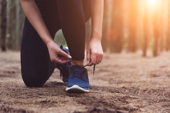 女人系鞋带当慢跑森林回来与喝水瓶旁边她的<strong>运动鞋</strong>绳子系人和生活方式概念医疗保健和健康主题公园和在<strong>户外</strong>主题