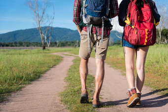 关闭较低的腿两个旅行者走沿着路径自然徒步旅行和野营概念背包客旅游概念在户外活动和冒险主题回来视图角