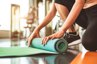 关闭运动女人折叠瑜伽床垫体育运动健身健身房<strong>培训中心</strong>背景锻炼席滚动保持后瑜伽类锻炼和体育运动培训概念手地毯