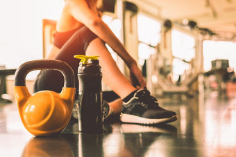 关闭壶铃与女人锻炼锻炼健身房健身打破放松后体育运动培训与蛋白质摇瓶背景健康的生活方式健身和运动员肌肉哑铃