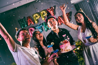 亚洲朋友有有趣的生日聚会，派对晚上俱乐部与生日蛋糕事件和周年纪念日概念人生活方式和友谊