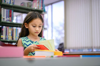 可爱的小女孩阅读书图书馆用心学校女孩集中学习自己外教室教育和人生活方式学术和孩子们责任概念
