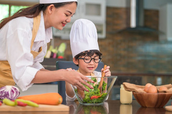 快乐美丽的亚洲女人和可爱的小男孩与眼镜准备烹饪厨房首页<strong>人生</strong>活方式和家庭自制的食物和成分概念两个泰国<strong>人生</strong>活