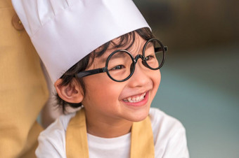 肖像可爱的小亚洲快乐男孩感兴趣烹饪与妈妈。有趣的首页厨房人生活方式和家庭自制的食物和成分概念烘焙圣诞节蛋糕和饼干