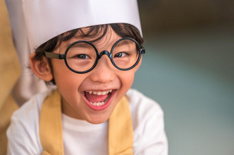 肖像可爱的小亚洲快乐男孩感兴趣烹饪与妈妈。有趣的首页厨房人生活方式和家庭自制的食物和成分概念烘焙圣诞节蛋糕和饼干