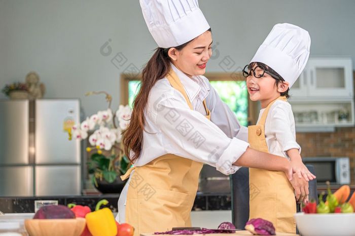 快乐美丽的亚洲女人衣服可爱的小男孩老板装为准备烹饪首页厨房人生活方式和家庭自制的食物和成分概念两个泰国人生活