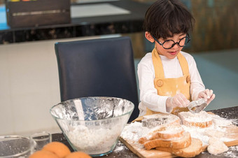 肖像可爱的小亚洲幸福男孩感兴趣烘焙面包店与有趣的首页厨房人生活方式和家庭自制的食物和成分概念烘焙圣诞节蛋糕和饼干