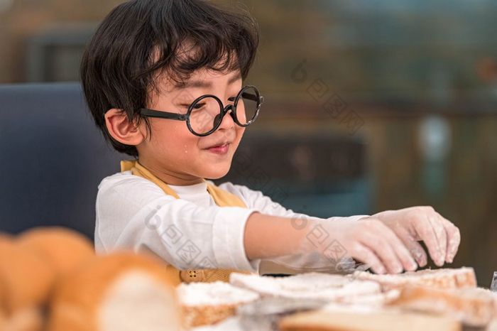 肖像可爱的小亚洲幸福男孩感兴趣烘焙面包店与有趣的首页厨房人生活方式和家庭自制的食物和成分概念烘焙圣诞节蛋糕和饼干