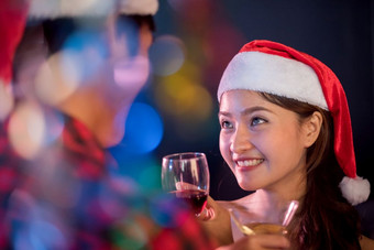 亚洲女人看她的的男朋友圣诞节和新一年聚会，派对晚上生活和第一个爱概念第一个印象和幸福概念夫妻和情人主题颜色模糊的散景前景