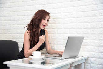 亚洲女人快乐后成功新开始项目在线投标与移动PC业务和成功人概念购物和促销活动概念技术和互联网沟通主题