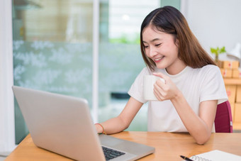 亚洲女人享受自己而使用笔记本电脑和互联网办公室业务和市场营销和部分时间概念行<strong>购物</strong>和业务成功<strong>主题</strong>快乐情绪做工作工作