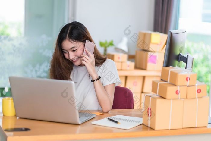 亚洲女人享受自己而使用互联网移动PC和电话办公室业务和市场营销和部分时间概念在线购物和业务成功主题快乐情绪做工作工作