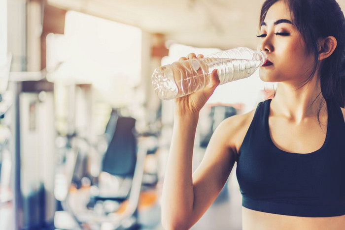 亚洲女人喝纯喝水为新鲜后锻炼锻炼培训健身健身房与健身设备背景放松和休息概念强度和健身培训主题