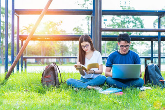 两个亚洲年轻的大学人讨论关于阅读书和使用移动PC为搜索和学习知识教育和友谊概念幸福和学习概念情人和朋友主题