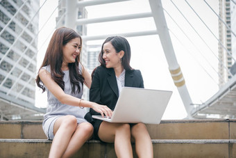 两个女商人工作移动PC电脑与快乐有趣的情感团队合作合作会议业务办公室员工技术协作市场营销和金融社区交互