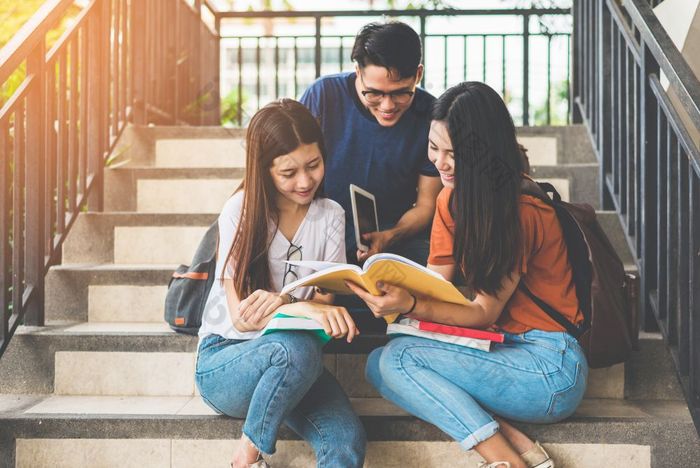 集团亚洲大学学生使用平板电脑和移动电话外教室幸福和教育学习概念回来学校概念青少年和人主题在户外和技术主题