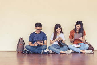 集团亚洲大学学生使用平板电脑和移动电话外教室幸福和教育学习概念回来学校概念青少年和人主题在户外和技术主题